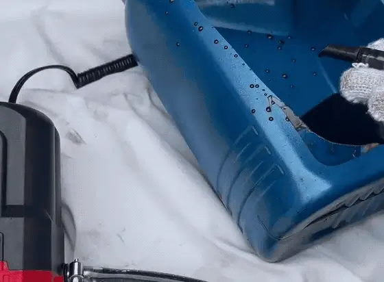 Warm oil climbing the clear outlet hose into a jug